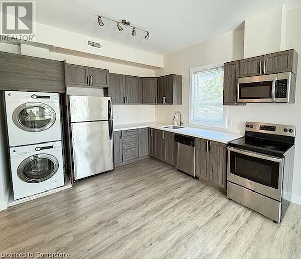 Kitchen+with+light+wood-style+floors+dark+brown+cabinets+stacked+washer+dryer+a+sink+and+stainless+steel+appliances Hamilton 2 bedrooms Apartment for rent. Property photo: 623891-3