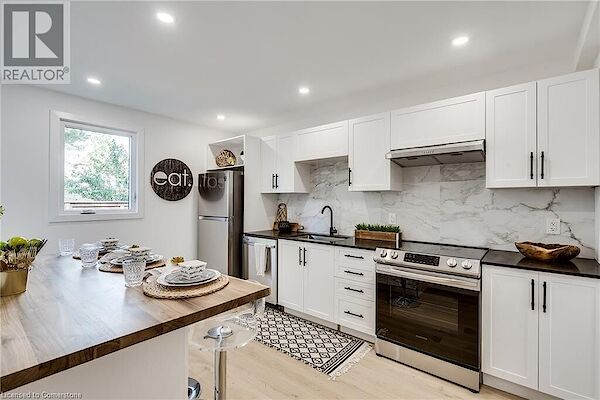 Kitchen+with+appliances+with+stainless+steel+finishes+under+cabinet+range+hood+white+cabinets+decorative+backsplash+and+light+wood-type+flooring Hamilton 2 bedrooms Townhouse for rent. Property photo: 646360-3